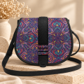 Duża listonoszka Mystic Mandala z kolorową klapką z drukowanego weluru we wzór mandali, czarnym wykończeniem i paskiem.